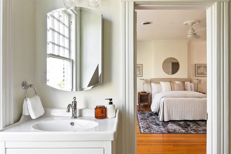 Bathroom vanity with a mirrored cabinet, looking through to the bedroom beyond